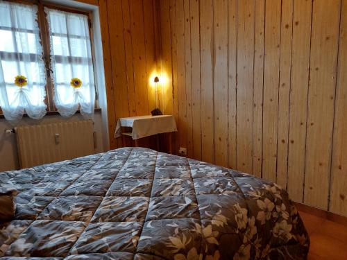1 dormitorio con 1 cama en una habitación con paredes de madera en Casa Vittoria, en Rivisondoli