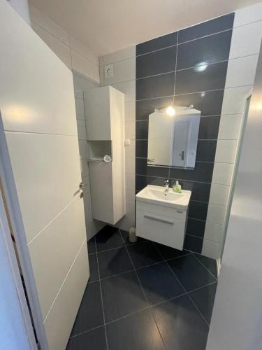 a small bathroom with a sink and a mirror at Apartman Dorotea in Zaton