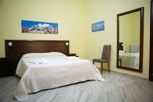 una camera da letto con un letto con specchio e una sedia di Villa Albertina Exclusive B&B a Parabita