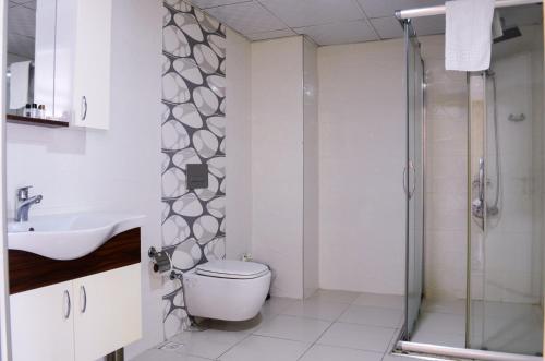 a bathroom with a shower and a toilet and a sink at Bilgehan Hotel in Antalya