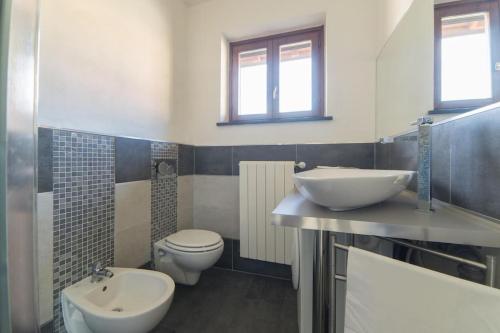 a bathroom with a toilet and a sink at Luxurious attic-swimming pool in Riva di Solto