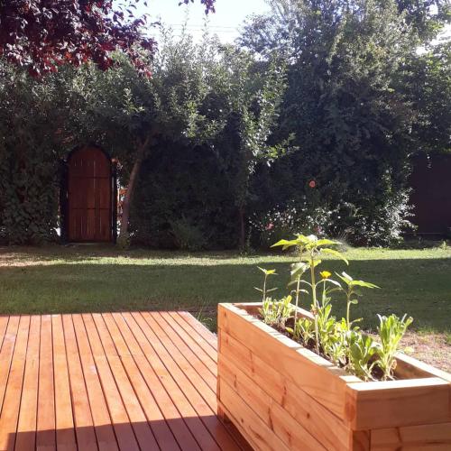 a wooden deck with a wooden box with plants in it at Arboleda Monoambiente in El Hoyo