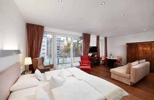 a bedroom with a white bed and a living room at 35qm Deluxe Apartment Suites im Stil Design Hotel Vosteen Nähe der Kaiserburg in Nuremberg