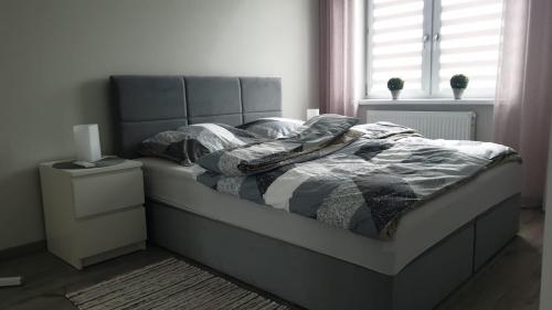 a bedroom with a bed and a window at Apartament STYL in Otmuchów