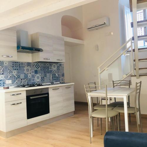 a kitchen and dining room with a table and chairs at B&B La Maison del Borgo in Rodi Garganico
