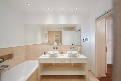 a bathroom with two sinks and a bath tub at 35qm Deluxe Apartment Suites im Stil Design Hotel Vosteen Nähe der Kaiserburg in Nuremberg