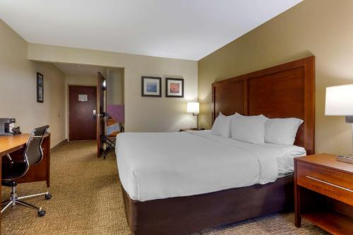 a hotel room with a large bed and a desk at Comfort Inn & Suites Cambridge in Cambridge