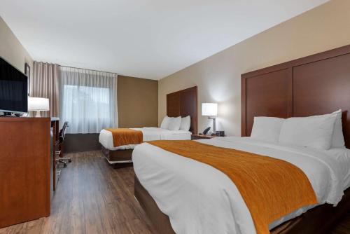 a hotel room with two beds and a flat screen tv at Comfort Inn Binghamton I-81 in Binghamton