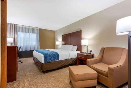 a hotel room with a bed and a chair at Comfort Inn Binghamton I-81 in Binghamton