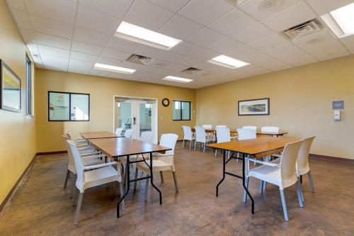 a conference room with wooden tables and white chairs at Comfort Inn & Suites Mandan - Bismarck in Mandan