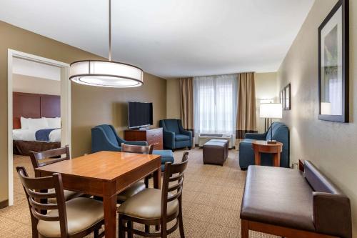a room with a dining table and a living room at Comfort Inn & Suites Northern Kentucky in Wilder