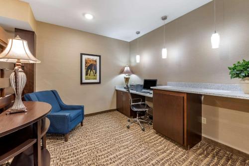 an office with a desk and a blue chair in a room at Comfort Inn & Suites Northern Kentucky in Wilder