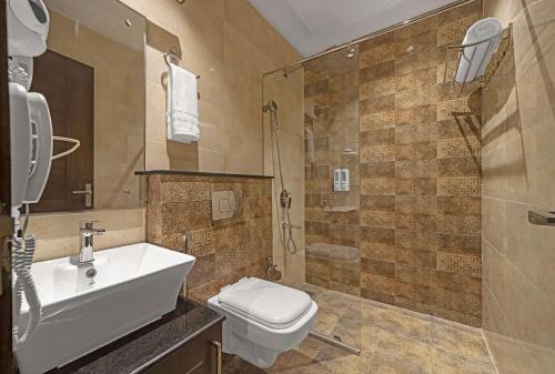 a bathroom with a toilet and a sink and a shower at Eastlynn Resort Rishikesh in Rishīkesh