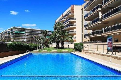 a swimming pool in front of a building at APPART STANDING 2 chambres 2SDB clim PISCINE PARKING WIFI TERRASSE 21m2 LOCAL VELO Port-Aventura, plage, centre in Salou