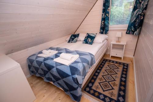 a small bedroom with a bed in a tiny house at Kwiat Paproci in Ryn