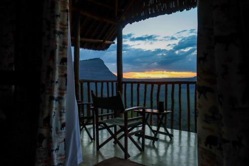 a room with a chair and a table on a balcony at Maili Saba Camp in Nakuru