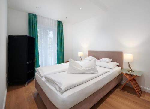 a bedroom with a large white bed with green curtains at 120qm Deluxe Apartment Suites Christina im Stil Design Hotel Vosteen Nähe der Kaiserburg in Nürnberg