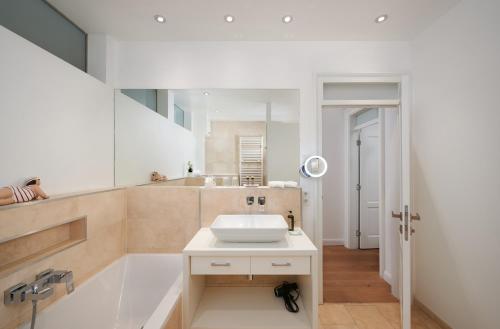 a bathroom with a sink and a bath tub at Deluxe Apartments Christina 120 m² im Design Hotel Vosteen in Nuremberg