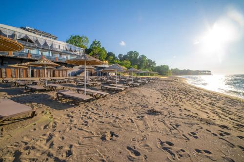 a beach with chairs and umbrellas and the ocean at Atik Hotel in Unye