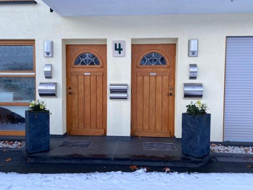 a house with two wooden doors in the snow at Fewo Rheinwein 1 "ausgezeichnet zum wandern und radfahren" mit Wallbox in Boppard