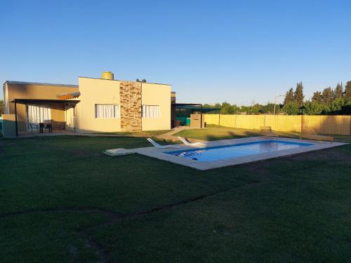 un patio con piscina frente a una casa en Cabañas Mágico Atardecer en San Rafael
