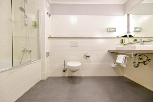 a bathroom with a toilet and a sink and a shower at Landhotel Burg im Spreewald - Resort & Spa in Burg