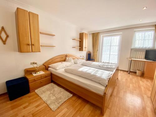 ein Schlafzimmer mit einem großen Bett und einem TV in der Unterkunft App. Cesa Vedla in St. Ulrich in Gröden