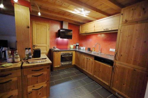 a large kitchen with wooden cabinets and a sink at Le Valombré in Saint-Pierre-de-Chartreuse