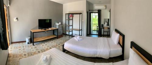 a hotel room with two beds and a television at D-2 Home in Chanthaburi