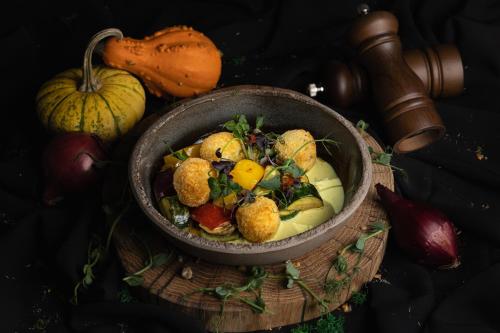a bowl of food on a wooden table with pumpkins at VISLOW Resort in Wisła