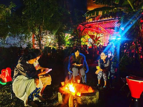 a group of people sitting around a fire at night at Dream Vision Guest House in Diu