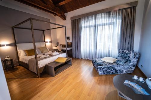 Hotel Cave Del Sole في ماتيرا: غرفة نوم بسرير وكرسي في غرفة