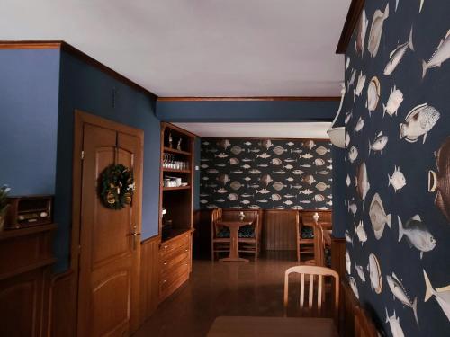 un comedor con una pared azul con fantasmas. en Willa Bursztynowa, en Rewa