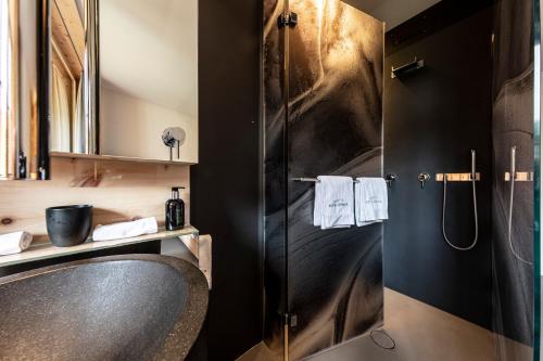 ein Bad mit einem Waschbecken und einer Dusche in der Unterkunft Hotel Arnica Scuol - Adults Only in Scuol