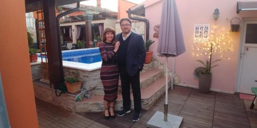 a man and a woman standing next to a pool at Bed & Breakfast Villa Adriana in Premantura