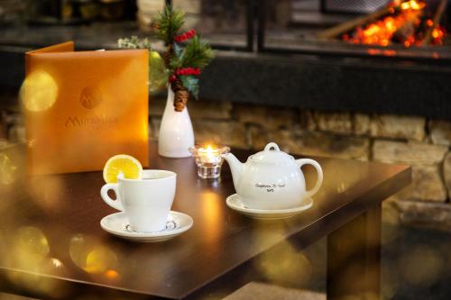 a table with two tea cups and a teapot at Hotel Mursalitsa by HMG - Half board in Pamporovo