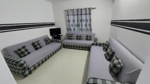 a living room with two couches and a television at Residence Cocotier in Centre de Flacq