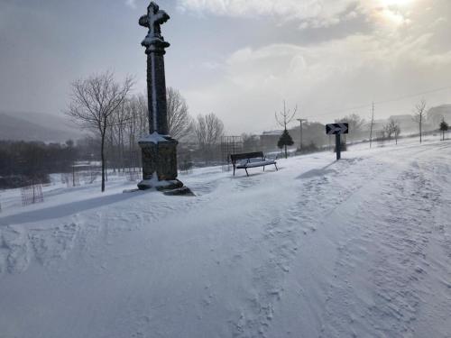 a snow covered park with benches and a light pole at Hotel Virginia R.H. in Vinuesa