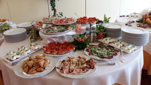 a table with many plates of food on it at Hotel Principe in Pomezia