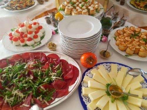 a table with plates of food and plates of food at Hotel Principe in Pomezia