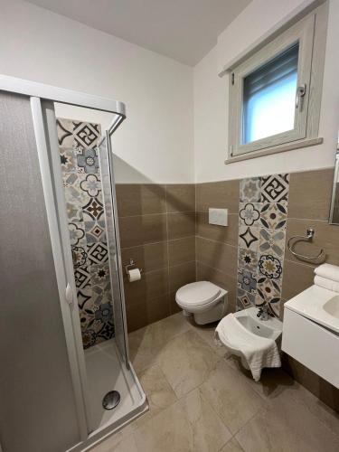 a bathroom with a shower and a toilet and a sink at B&B Quintadecima in Uggiano la Chiesa