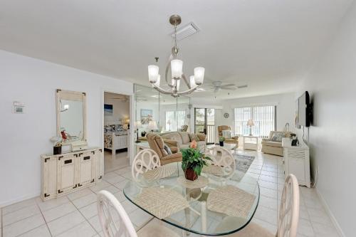 a dining room with a glass table and chairs at Anna Maria Island Beach Sands 203 in Bradenton Beach