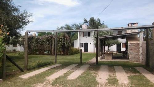 an open garage in front of a white house at Los Gurises in Gualeguay