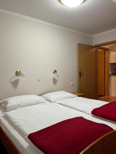 1 Schlafzimmer mit 2 Betten mit weißer und roter Bettwäsche in der Unterkunft Apartma Anastasija in Kranjska Gora