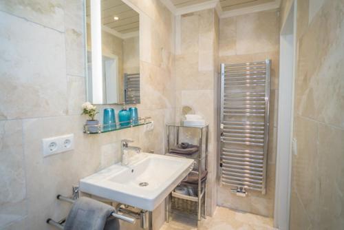 La salle de bains est pourvue d'un lavabo blanc et d'un miroir. dans l'établissement Rotkäppchen, à Westerland