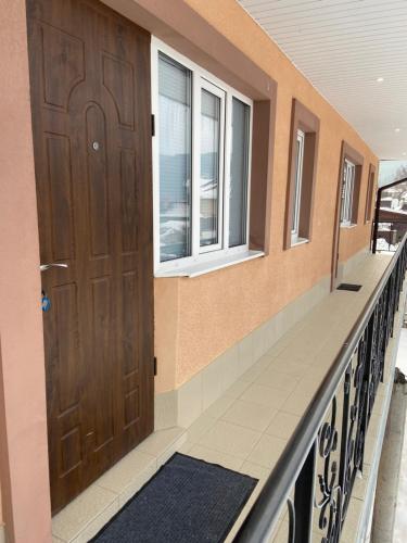 a balcony with a wooden door and windows at ZWIN Apartment 2 in Skole