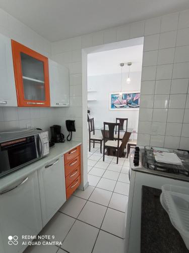 a kitchen with a sink and a microwave at Village Hospedagens in Natal