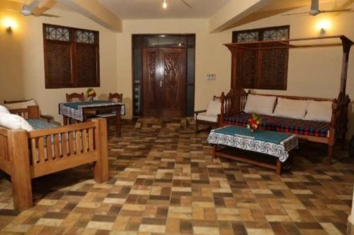 ディアニ・ビーチにあるEnchanting 3bed Villa with Ac &poolのベンチとテーブルが置かれた広い部屋