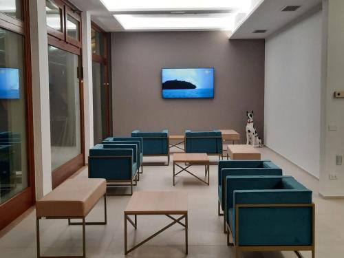 a waiting room with chairs and a tv on a wall at Hotel Al Giardino in Treviso
