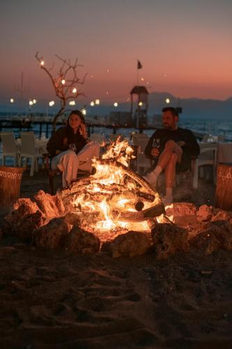 a man and a woman sitting around a fire at RAW BEACH HOTEL in Antalya